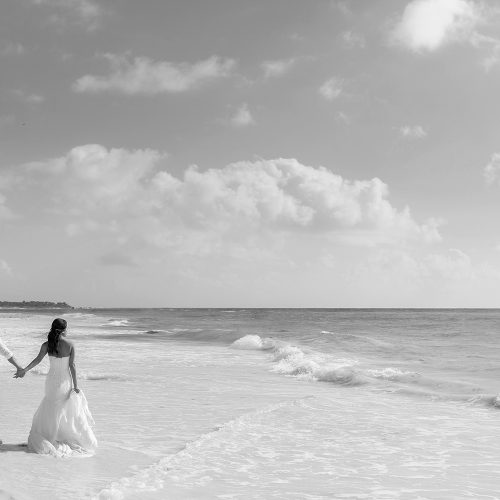 Bride and groom walking down beach wet after TTD on beach on beach in Riveira Maya Mexico