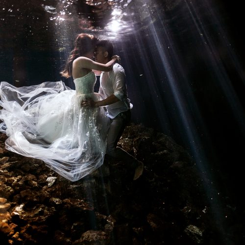 Bride and groom kissing underwater at Cenote Trash the Dress (TTD) in Mexico