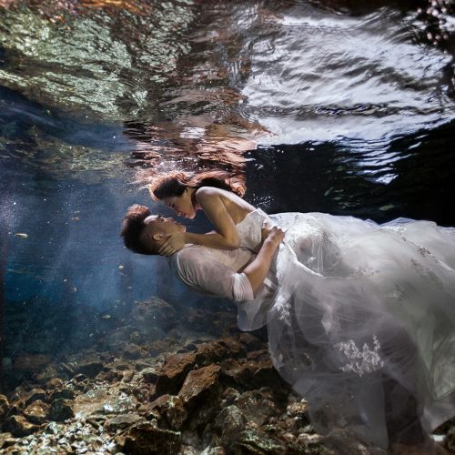 Bride on top of groom in underwater Cenote Trash the Dress (TTD) in Mexico