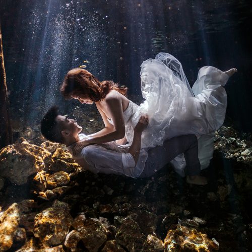 Bride on top of groom in Cenote Trash the Dress (TTD) in Mexico