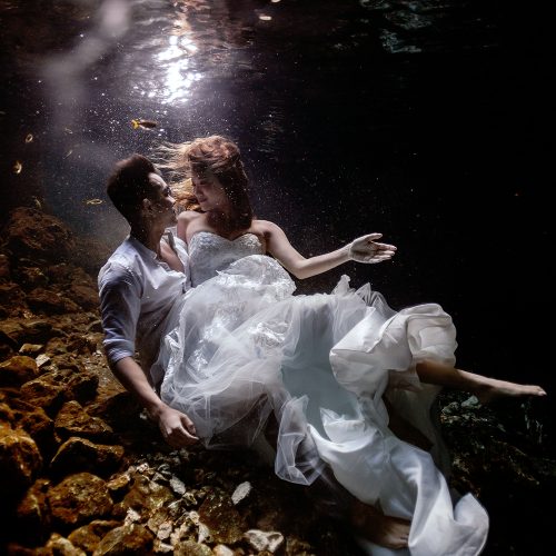 Bride and groom in romantic pose at underwater Cenote Trash the Dress (TTD) in Mexico