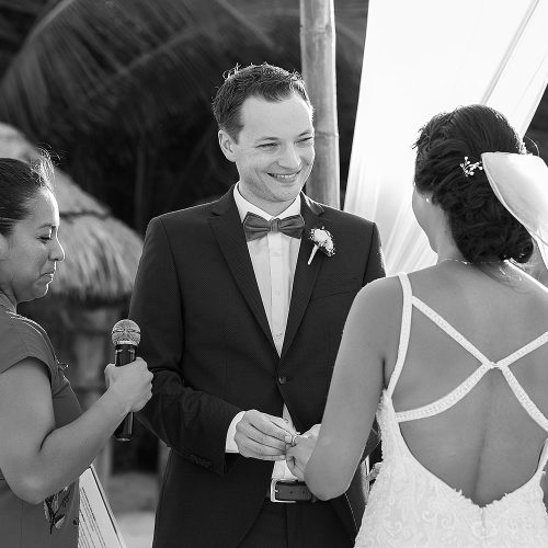 Groom putting on ring at wedding ceremony at Punta Venado, Riviera Maya