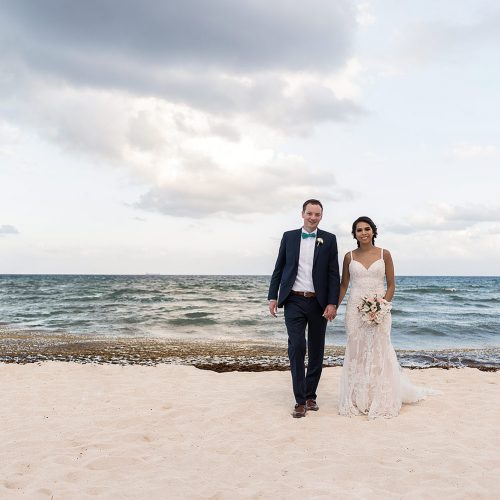 Bride and groom holding hands walking on beach at Punta Venado, Riviera Maya