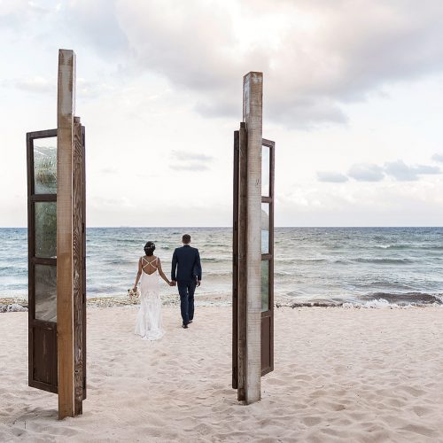 Bride and groom walking away on beach at Punta Venado, Riviera Maya Mexico