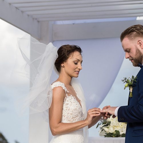 Bride putting on rings during wedding ceremony at Azul Fives sky deck