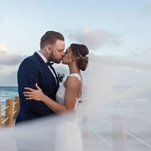 Bride and groom kissing on dock at Azul Fives Riviera Maya