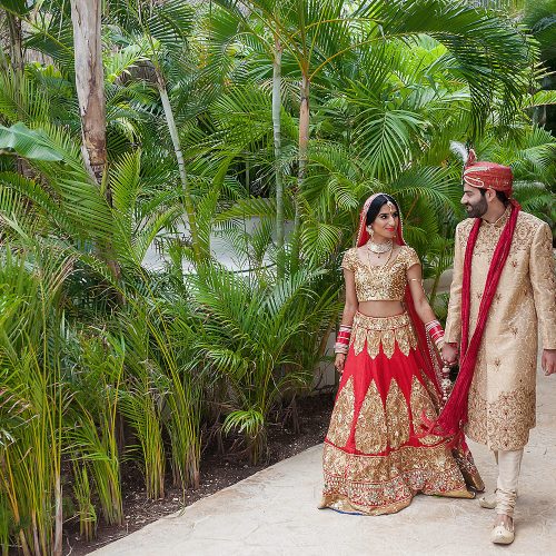 Indian bride and groom walking on holding hands