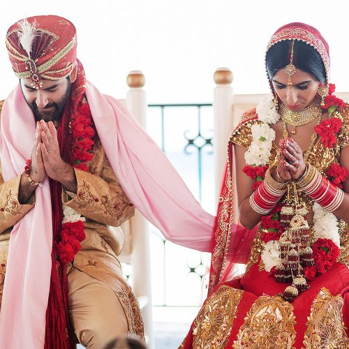 Bride and groom praying during Indian wedding ceremony