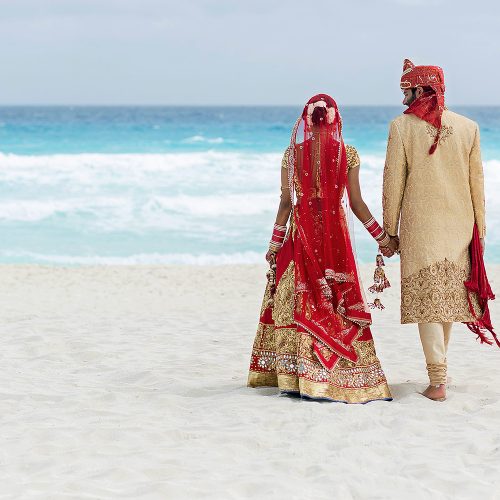 Indian bride and groom on beach after wedding ceremony