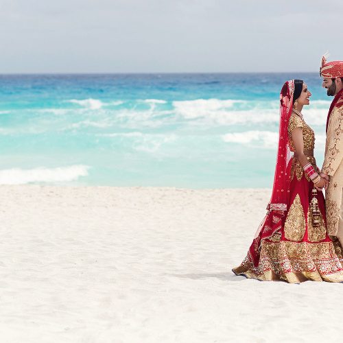 Indian bride and groom on beach in Cancun after wedding.