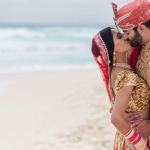 Bride and groom kissing on beach in Cancun
