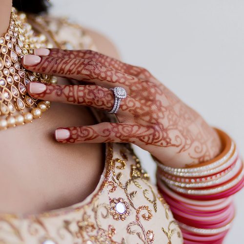 Close up of bride with henna, necklace and wedding ring.