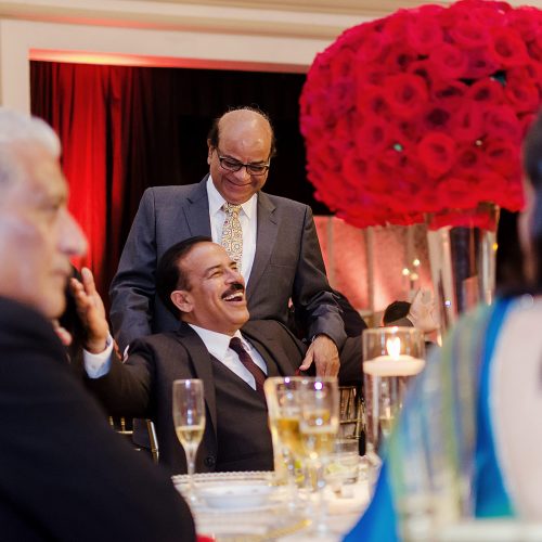 Candid photograph of guests laughing at Indian wedding reception