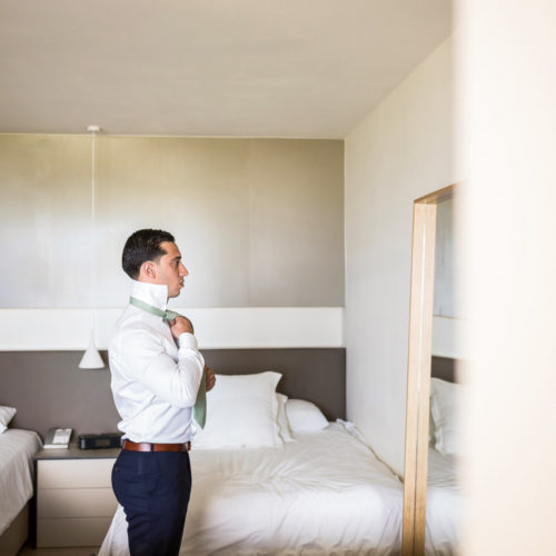 Groom getting ready in front of mirror at Finest Playa Mujeres