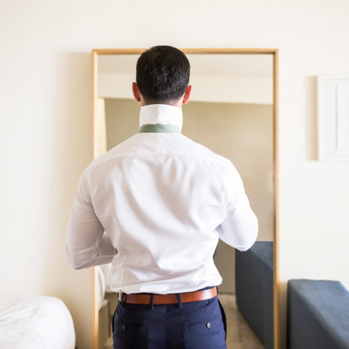 Groom getting ready in hotel room.