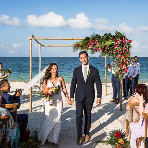 Bride and groom walking after beach wedding ceremony