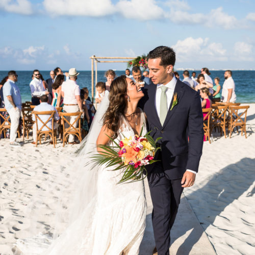 Bride and groom shortly after wedding ceremony on beach.
