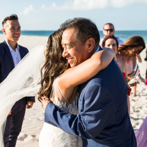 Bride hugging father after wedding.