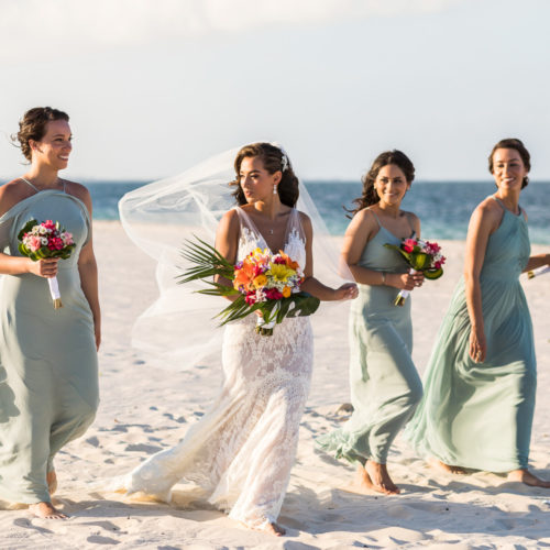 Bridesmaids walking on beach at Finest Playa Mujeres