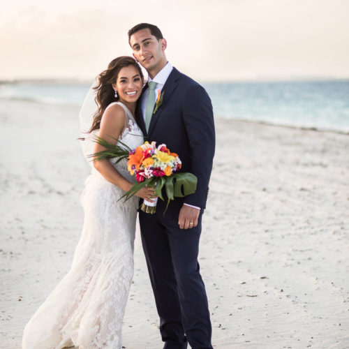 Portrait of bride and groom on beach.