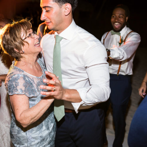 Mother dancing with groom at wedding reception.