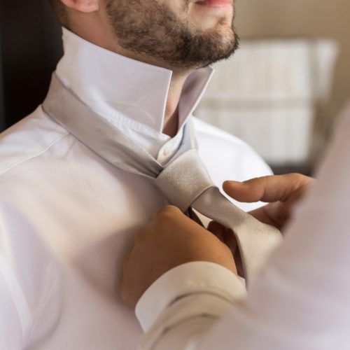 Groom doing up tie at wedding at NOW Sapphire Riviera Maya Resort