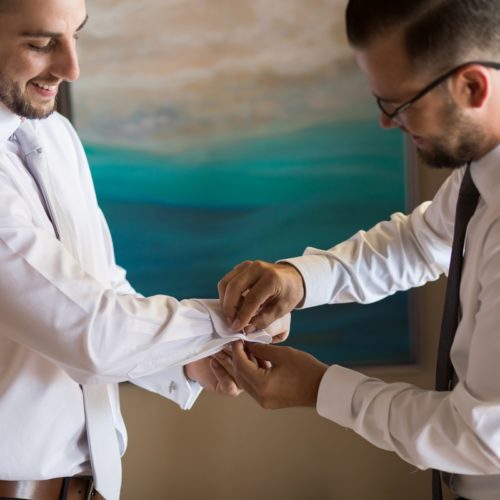 Groomsman helping groom.