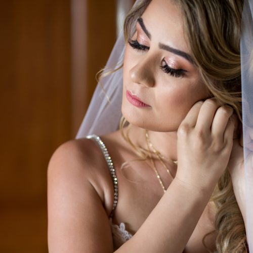 Bride putting on ear ring.