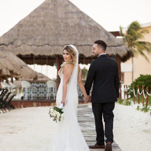 Bride and groom walking on boardwalk at Bride in gardens at NOW Sapphire Riviera Maya Resort