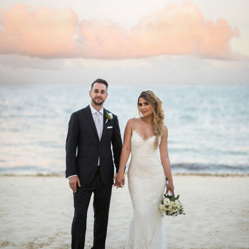 Portrait of bride and groom in front of Caribbean sea.
