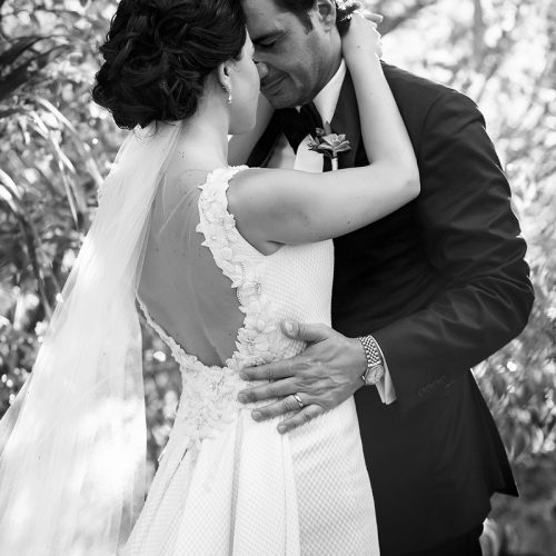 Bride and groom in romantic pose in black and white.