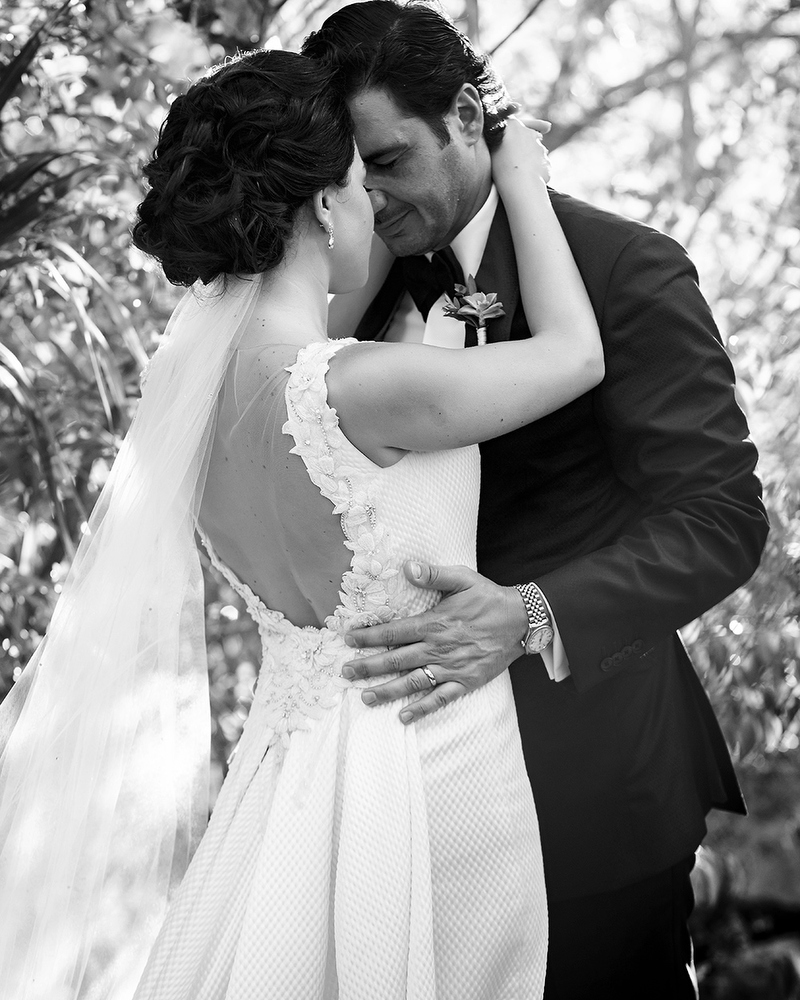 Bride and groom in romantic pose in black and white.