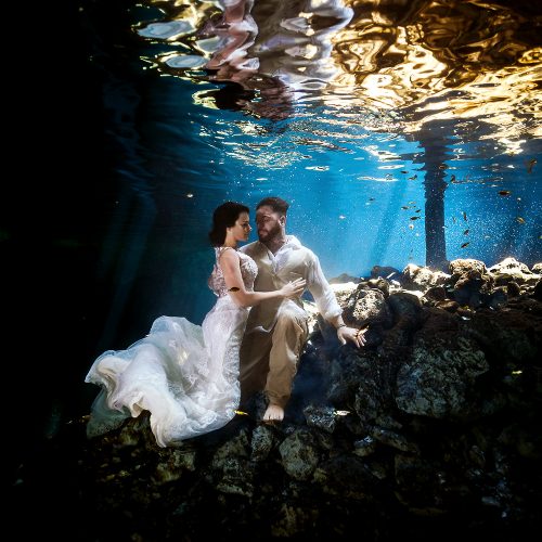 Bride and groom underwater in cenote on Mexico