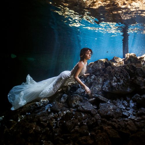 Bride underwater fashion in bridal dress.