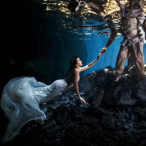 Bride holding grooms hand in underwater trash the dress (TTD)
