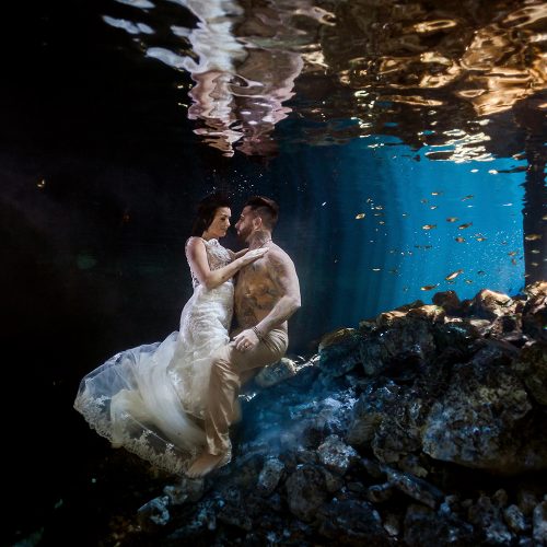 Bride and groom kissing underwater in Trash the Dress (TTD).