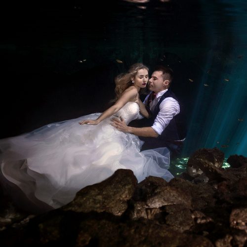 Bride and groom in romantic pose underwater in mayan Cenote Trash the Dress