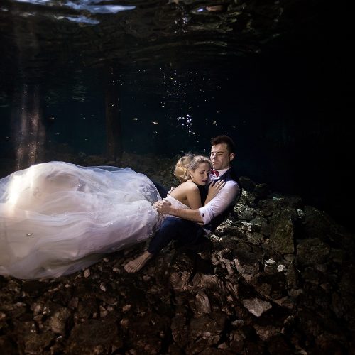Bride laying on groom underwater in cenote TTD