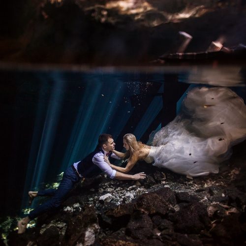 Bride and groom swimming together in Cenote Trash the Dress