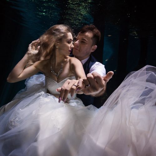 Bride and groom showing rings in Mayan Cenote Trash the Dress