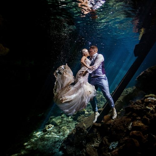 Bride and groom kissing underwater in Mayan Cenote Trash the Dress