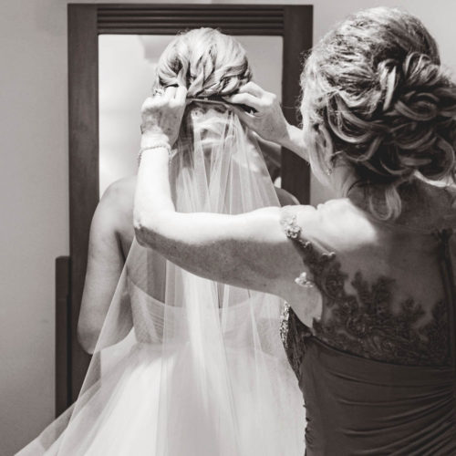 Mother helping bride get ready in front of mirror at iberostar paraiso beach resort