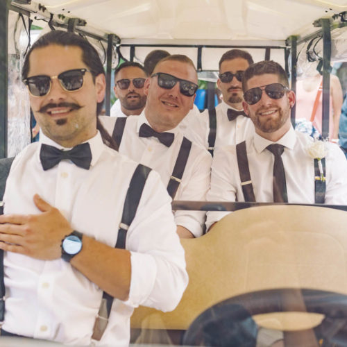 Fun photo of groomsmen in golf cart going to ceremony.