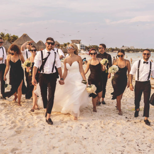 Casual photo of bridal party walking on the beach at iberostar paraiso beach resort