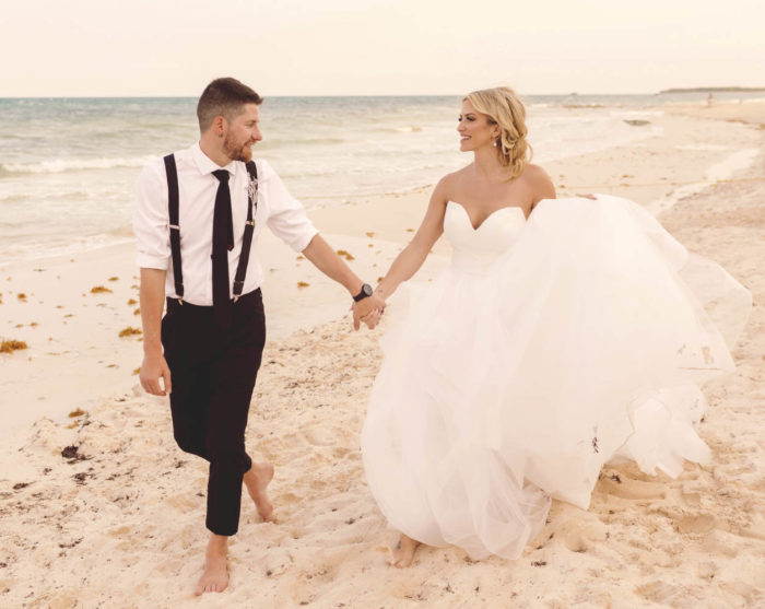 Groom walking with bride and having fun on beach at iberostar paraiso beach resort