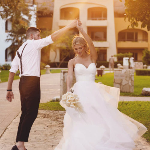 Groom twirling bride in gardens at iberostar paraiso beach resort