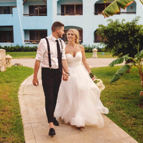 Groom walking with bride in gardens at iberostar paraiso beach resort