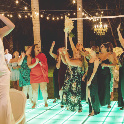 Girls catching bouquet at wedding reception.
