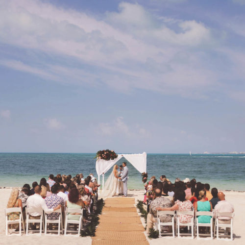 Wide angle photo of wedding ceremony on beach at Finest Playa Mujeres