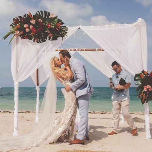 Bride and grooms first kiss at wedding ceremony at Finest Playa Mujeres